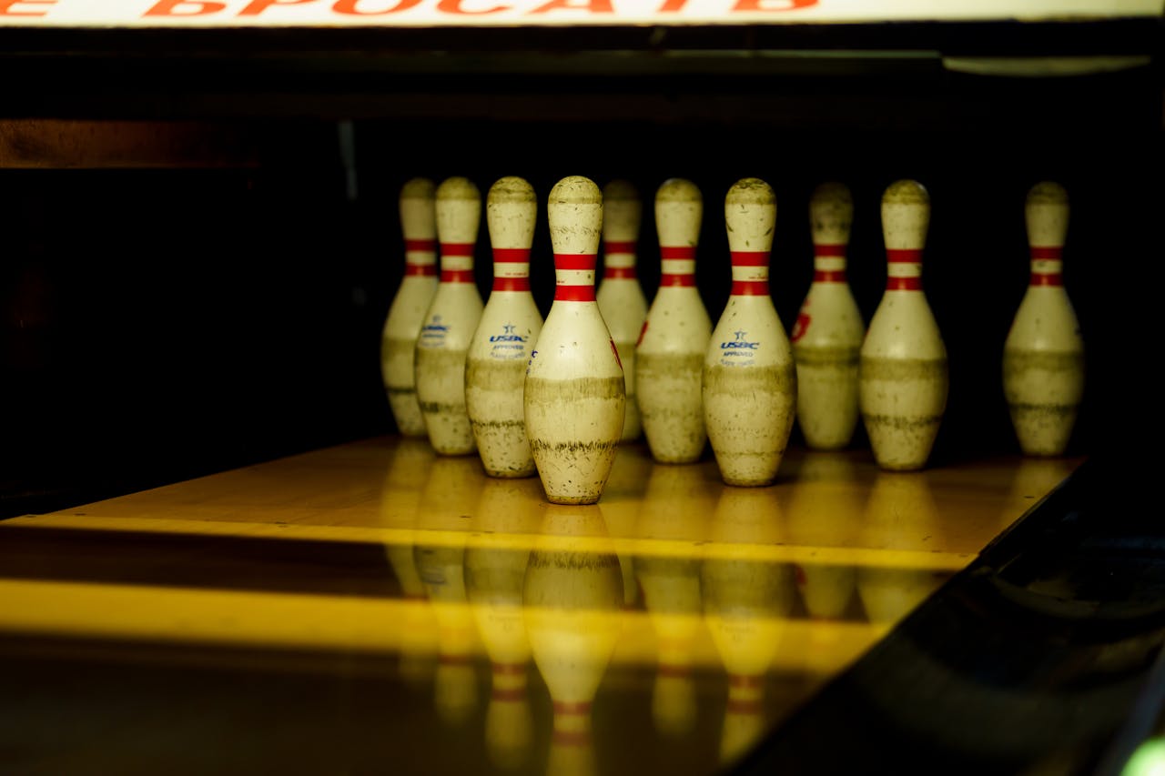 Close-up of arranged bowling pins on a lane, ready for a strike.